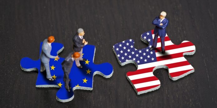 Puzzleteile mit den Flaggen von Europa und den USA Unstimmigkeit: Zunahme von autokratischen Handelspolitiken erfordert ein neues Risikomanagement bei M&A-Transaktionen.