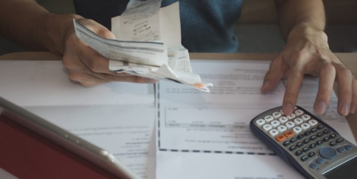 man using calculator for calculate expenses accounts Schulden aus vergangenen Zeiten: