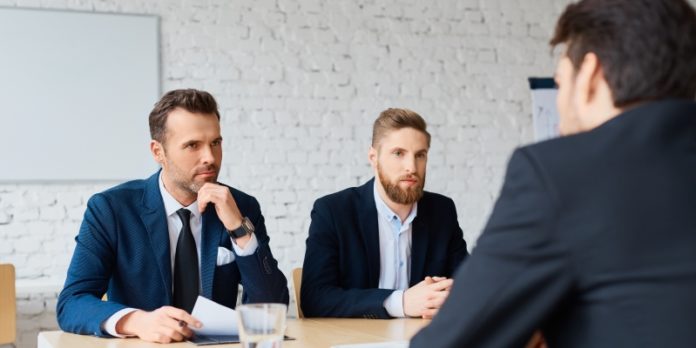 Job interview - two business man recruit candidate at their office Verhandlungsgeschick: