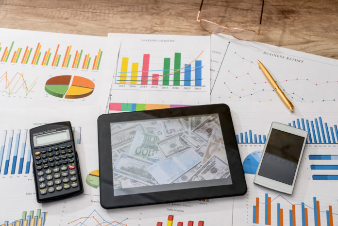 Tablet computer and financial charts, calculator, pen Umfangreiches Reporting: Aus Kosteneffizienzgründen bietet es sich an, dieses von einem Dienstleister erstellen zu lassen.