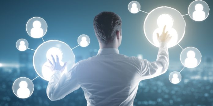 Back view of businessman on rooftop managing people icons. HR concept Finanzchefs und Digitalisierung: Neue Technologien haben begonnen, die Arbeitswelt des Finanzwesens zu erweitern, teils sogar zu revolutionieren.