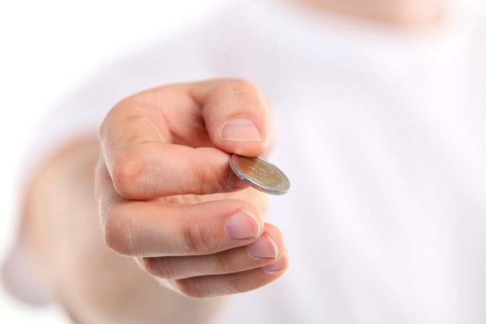 Young caucasian man holding a two euro coin