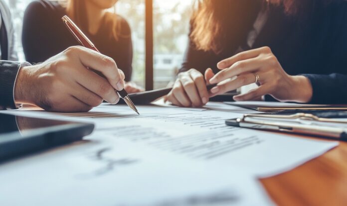 Legal team reviewing and revising clauses in contract with focus and collaboration Ein Unternehmensverkauf ist oft geprägt von Unsicherheit. Earn-out Klauseln können den Kaufpreis an die Entwicklung des Unternehmens knüpfen.