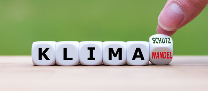 Symbol für mehr Klimaschutz: Hand dreht einen Würfel und ände (c) adobe_Stock