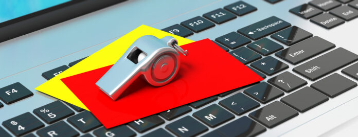 Whistle and red yellow cards on computer keyboard, banner. 3d illustration