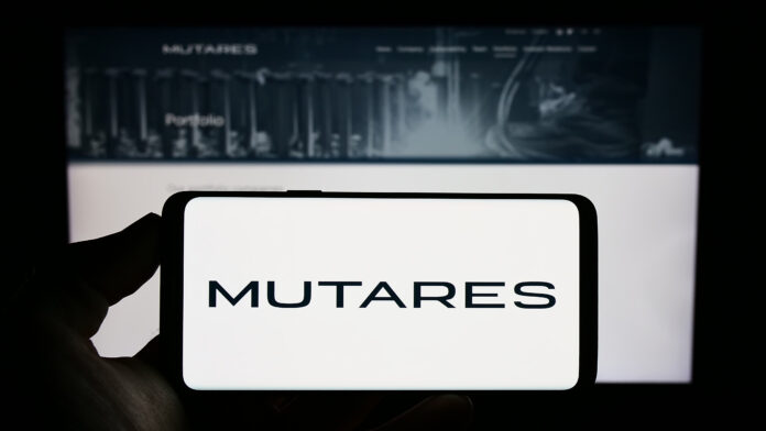 Stuttgart, Germany - 06-24-2023: Person holding smartphone with logo of German investment company Mutares SE Co. KGaA on screen in front of website. Focus on phone display.