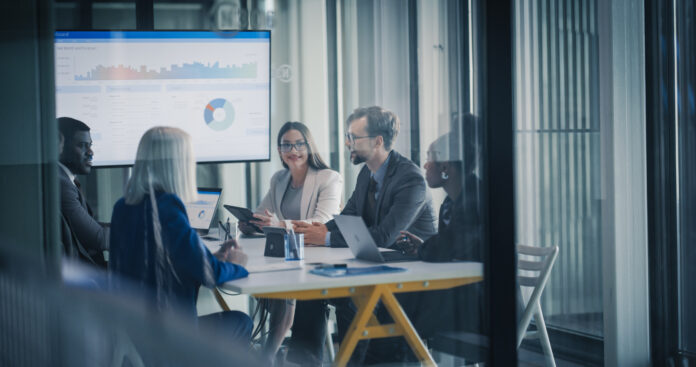 Business Team Meets in a Glass Conference Room to Review Dashboards, Discuss Financial Results, Set Revenue Targets, and Plan Strategy, Using Laptops and Tablets to Analyze Data, Share Insights Gesellschafterfinanzierung bietet GmbHs flexible Kapitaloptionen und stärkt Liquidität, Bonität sowie Investitionsspielraum.