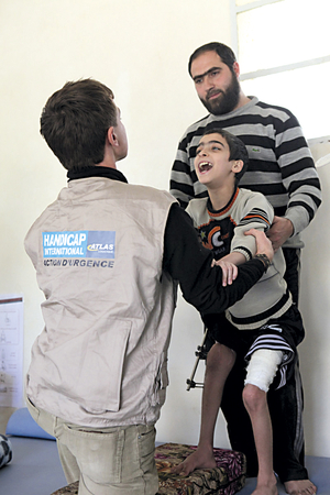 Syrien: Abdul und sein Vater beim Physiotherapeuten von Handicap International. Bild: Handicap International